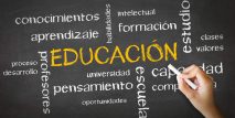Una persona dibujando y apuntando a la palabra EDUCACIÓN escrita con tiza
